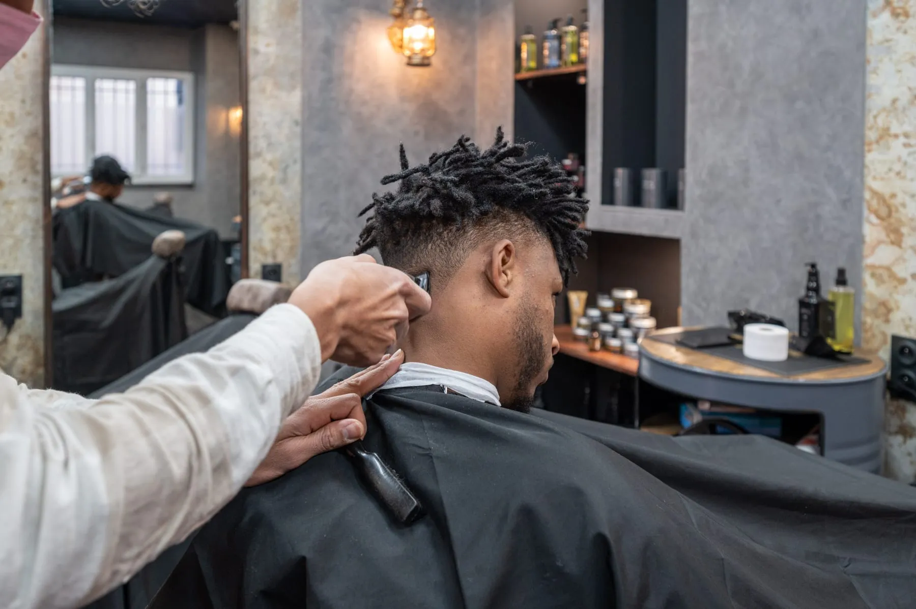 Un barbier d'Allure Barber au travail sur un dégradé.